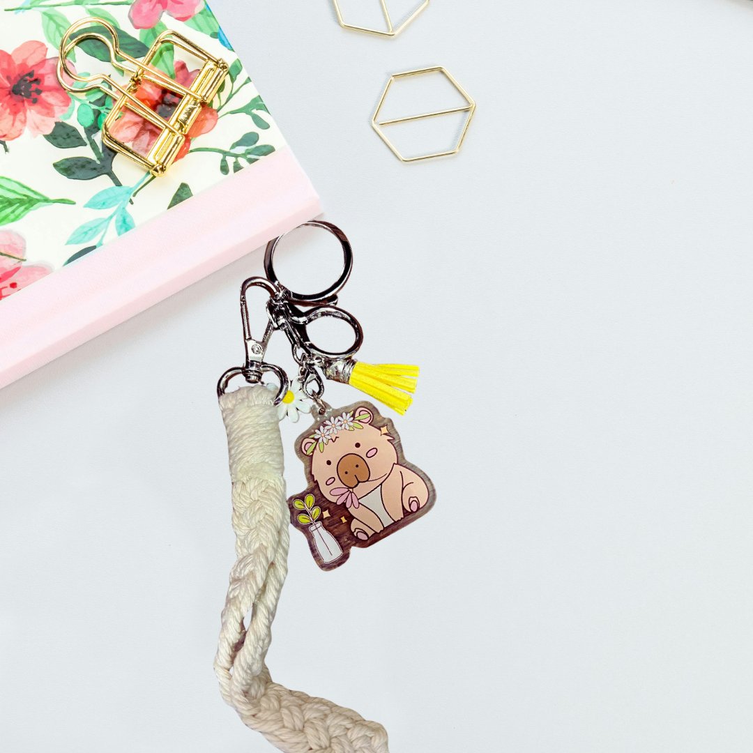 Hippie the Capybara acrylic keychain attached to bag with rope strap and tassel