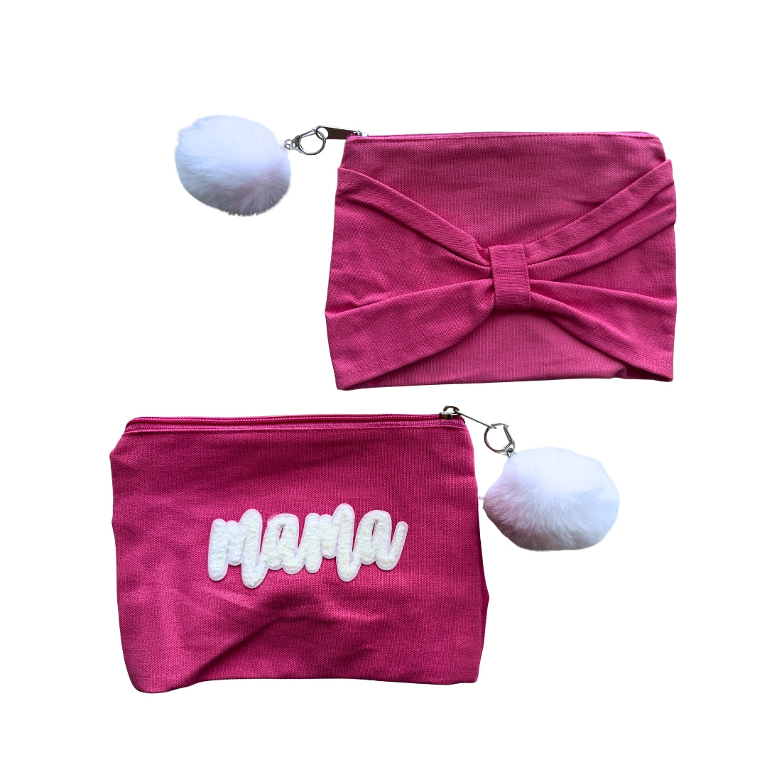 Front and back view of the pink Mama canvas zipper pouch featuring a large bow, chenille MAMA lettering, and fluffy pom-pom zipper charm.