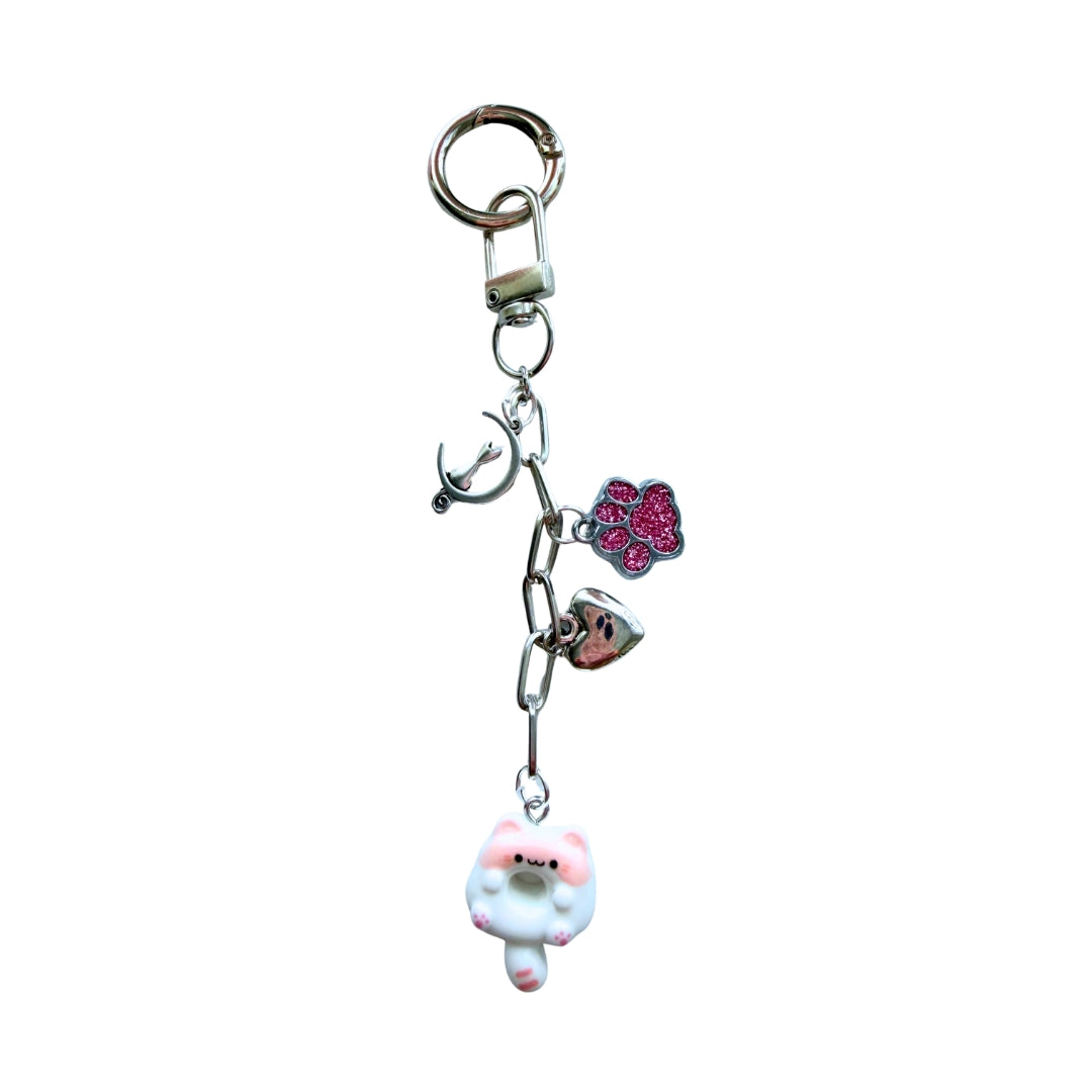 Handmade pink kitty donut purse charm with glitter paw print, heart, fishbone charm, and silver hardware on a white background.