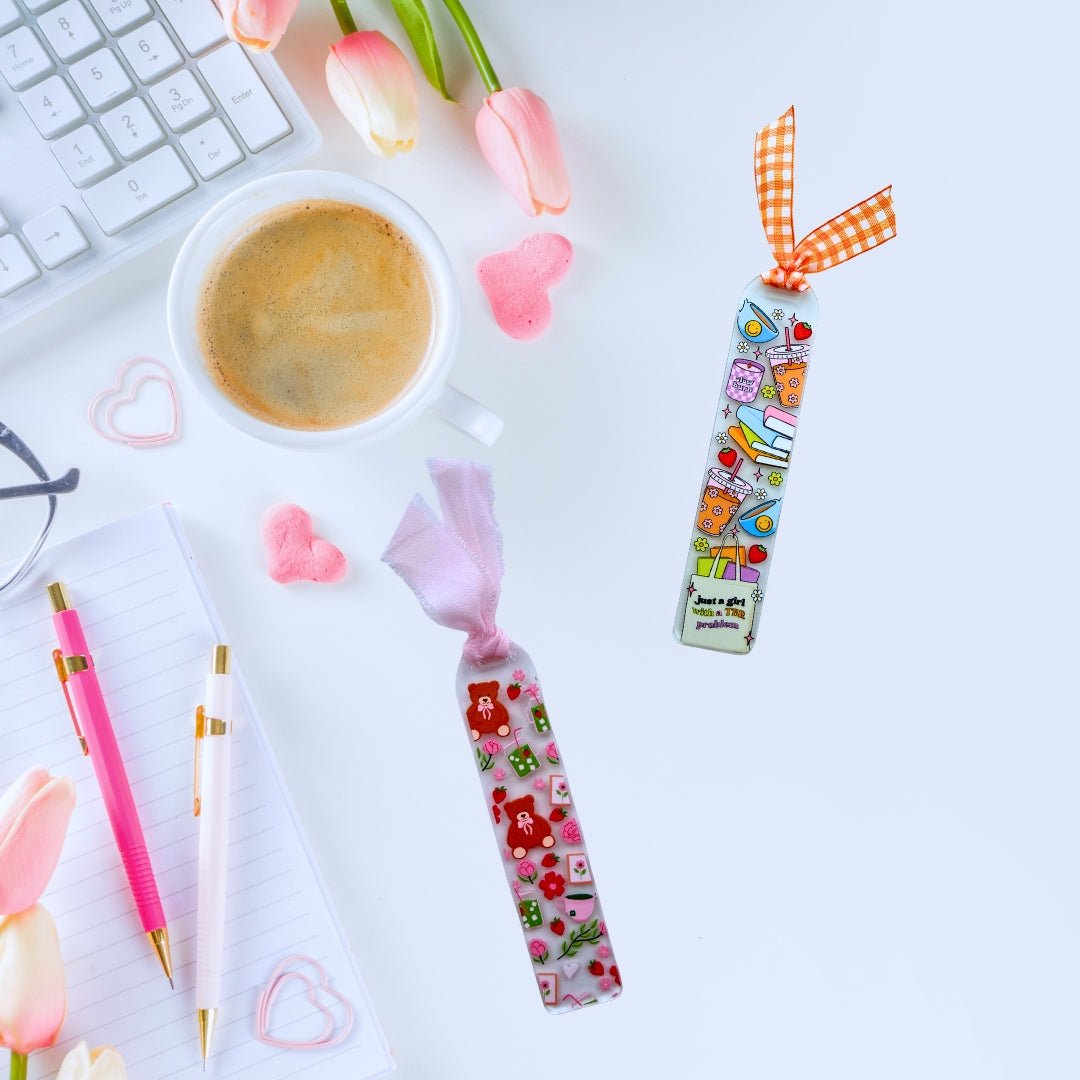 Colorful acrylic bookmarks with ribbons styled beside coffee and stationery