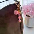 Pink Beaded Star Purse Charm clipped to brown handbag with gold-tone star accents and fluffy pom