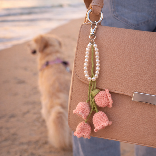 Crochet flower purse charm with pearl wristlet hanging from handbag during beach walk with dog