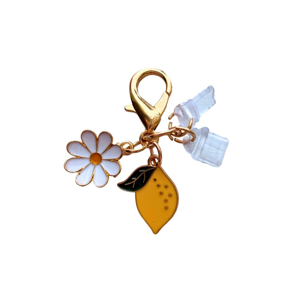 Lemon Daisy phone dust plug charm with white daisy, yellow lemon, gold clasp and interchangeable charging port covers.