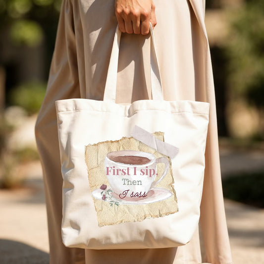 Outdoors woman walking holding a tote with a sticky note and image of coffee cup with word "first I sip, then I sass."