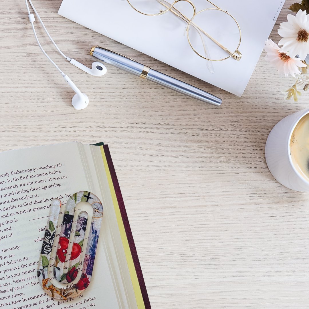 Inspirational acrylic bookmark used in book with coffee and desk setup