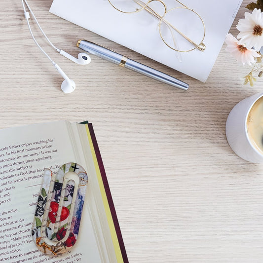 Inspirational acrylic bookmark used in book with coffee and desk setup