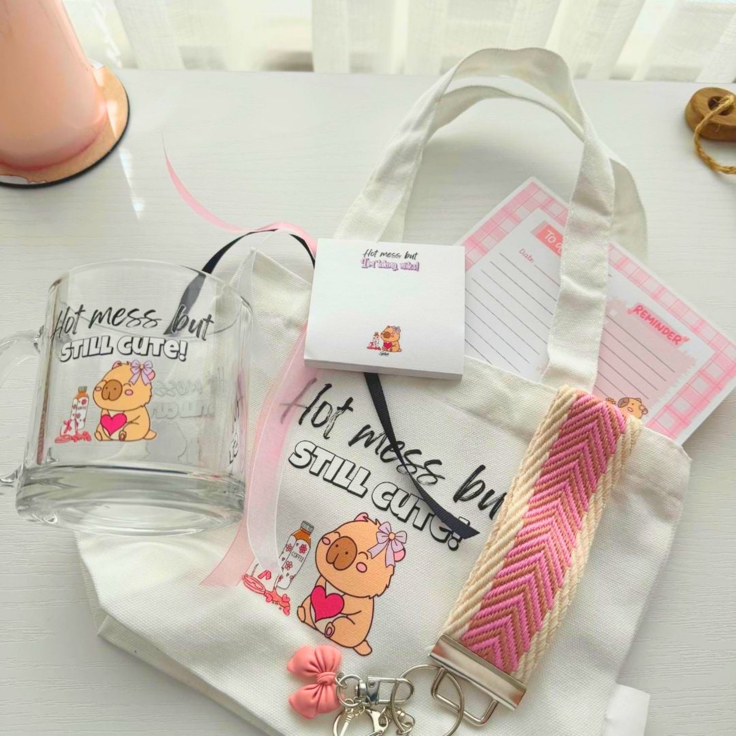 Close up of hot mess capybara mug, tote bag and stationery gift bundle items