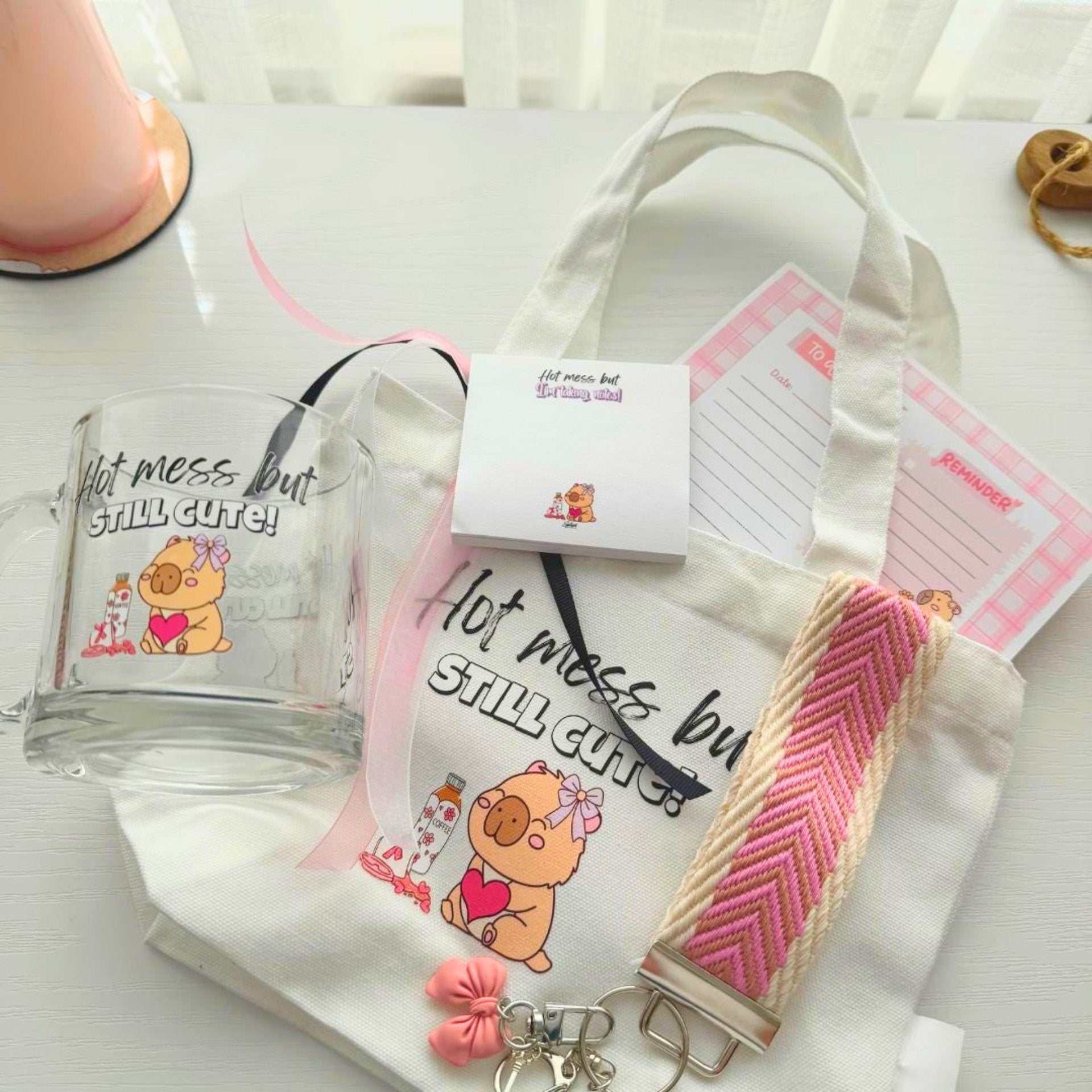 Close up of hot mess capybara mug, tote bag and stationery gift bundle items