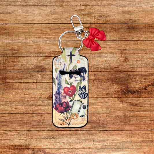 Neoprene lip balm holder keychain with forgiven design and red bow charm on wood background