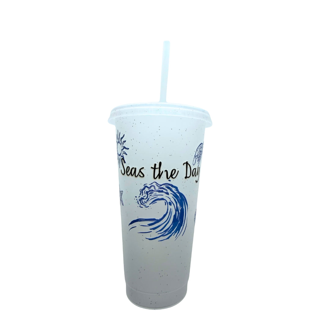 24 oz glitter plastic tumbler featuring the Seas the Day coastal design with a wave, sea turtle, starfish, and reusable straw.