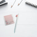 White desktop with sticky note pad andpen.