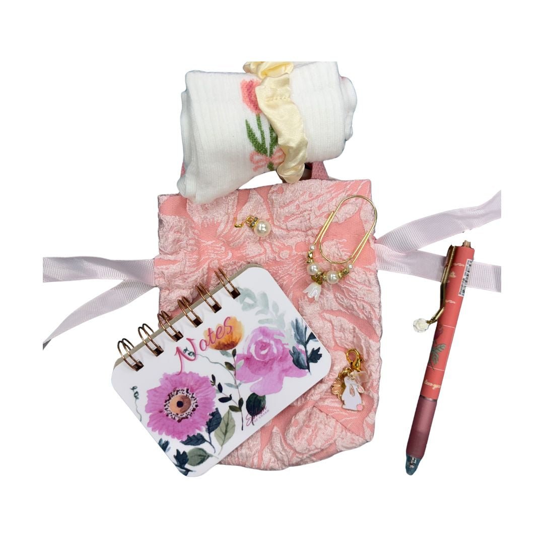 Tiny Reset Gift Set featuring a floral notepad, rose pen, cozy accessories, and soft pink self-care aesthetic