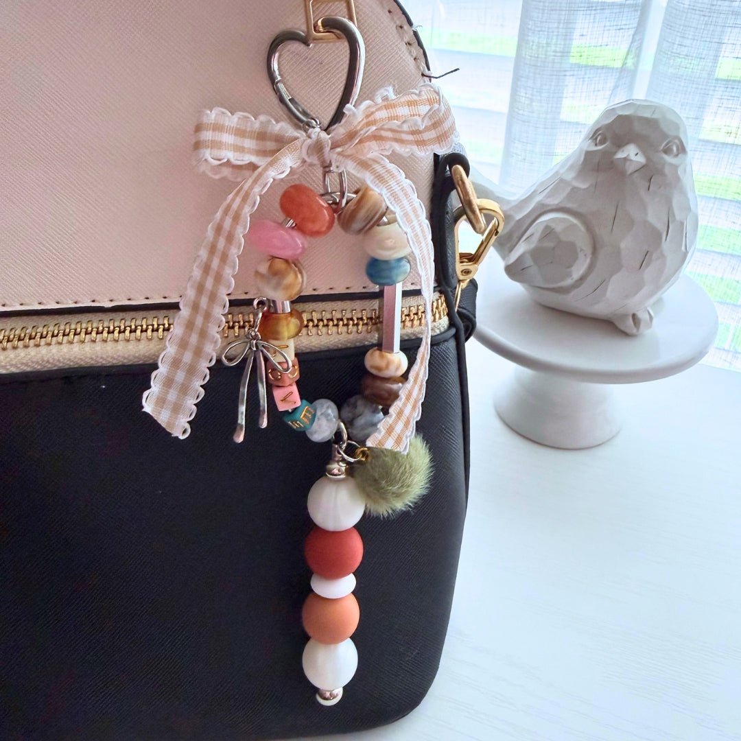 LOVE Word Story beaded bag charm clipped to a purse